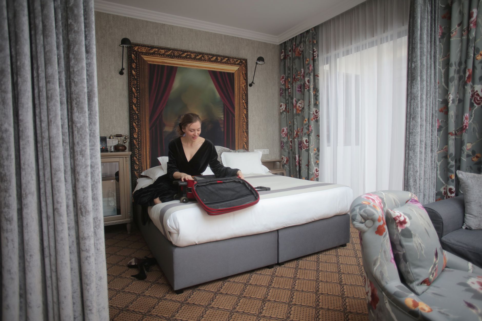 A woman in a chic hotel room packing her suitcase, ready for travel.
