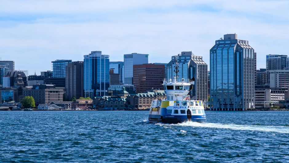 A ferry sails towards Halifax skyline, capturing the vibrant urban waterfront.