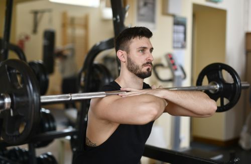 Free A focused man lifting weights indoors showcasing strength and concentration. Stock Photo