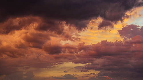 Free A vibrant and dramatic sunset sky filled with colorful clouds. Stock Photo