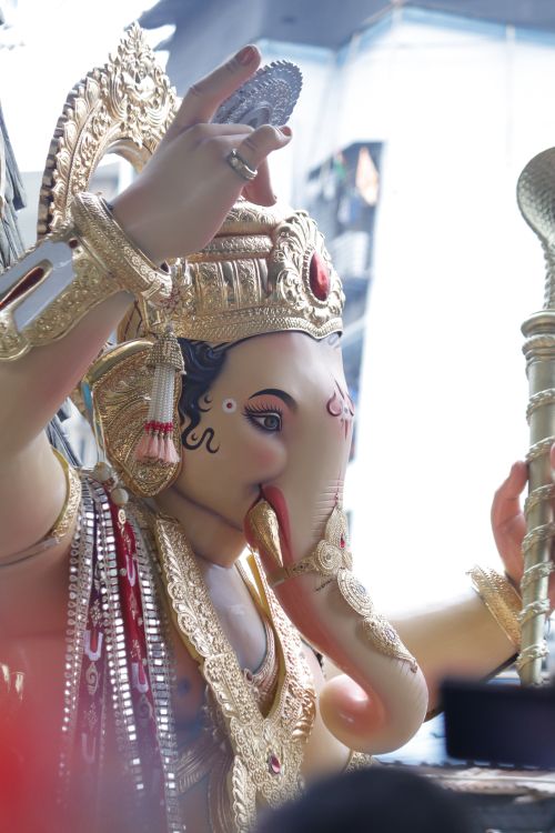 Free Stunning Lord Ganesha statue adorned with gold jewelry and traditional attire, conveying spiritual grace. Stock Photo