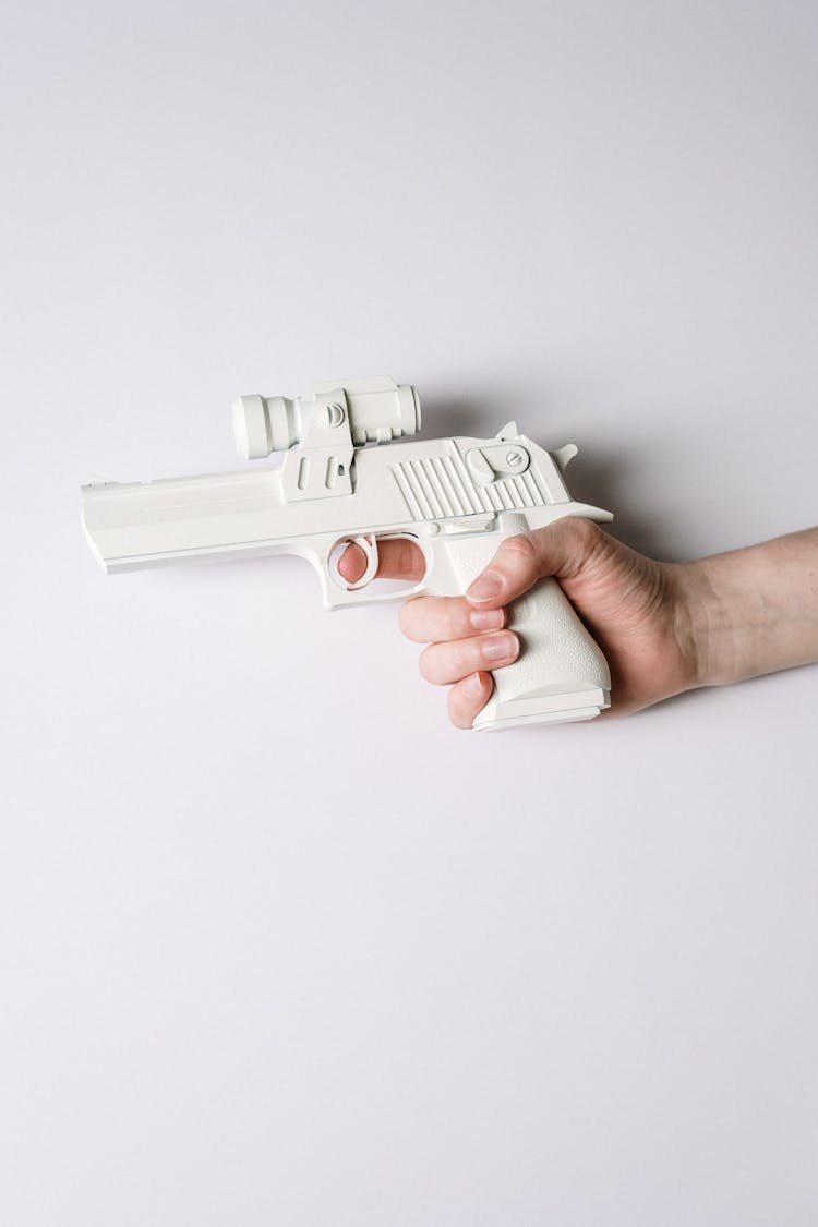 Person Holding White And Gray Semi Automatic Pistol