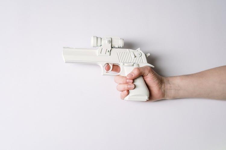 Person Holding White And Gray Semi Automatic Pistol