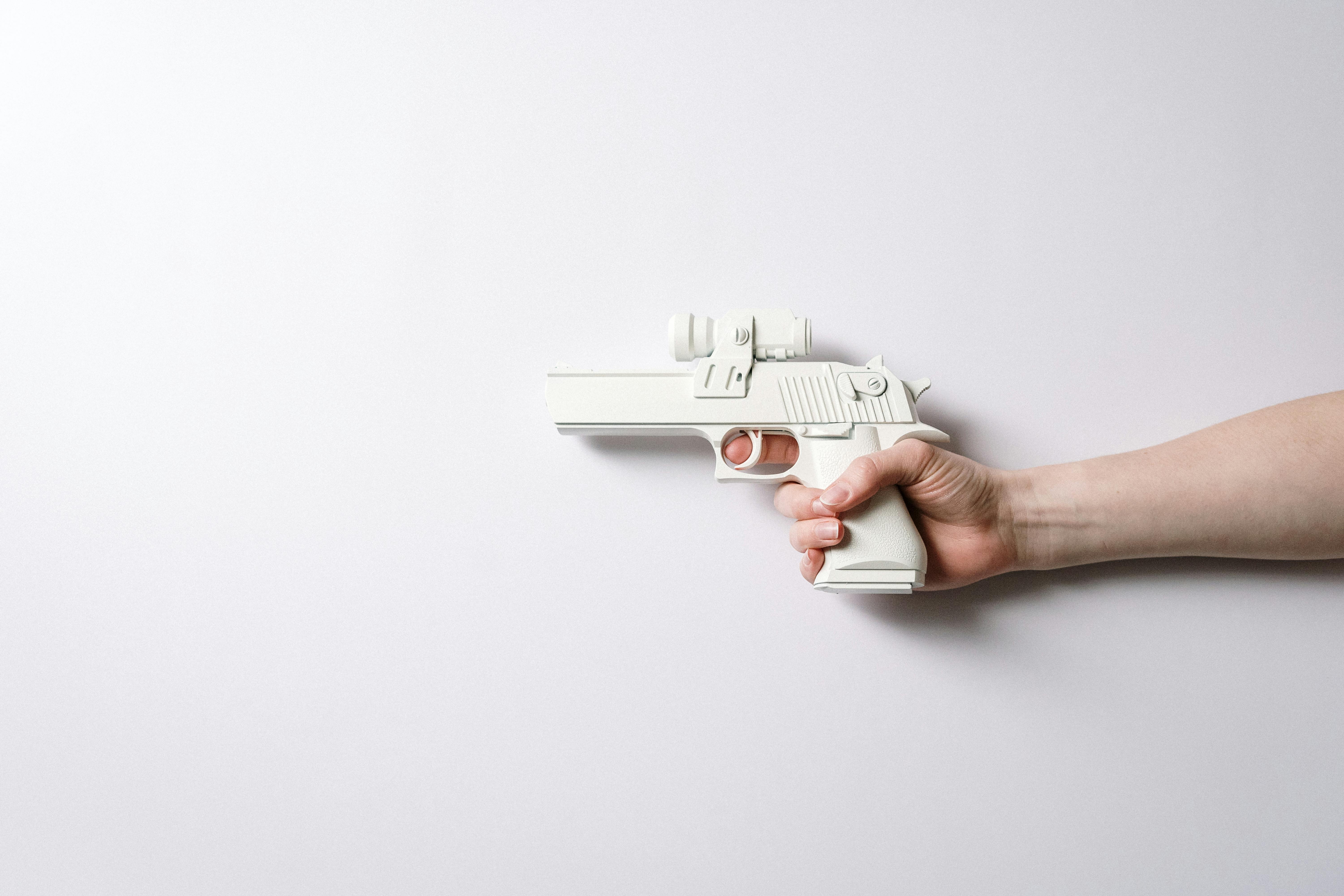 person holding white and gray toy gun