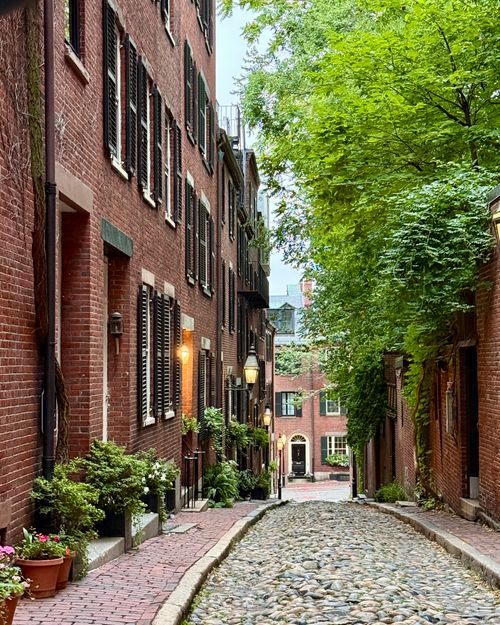 Free Cobblestone street lined with historic brick buildings in Boston's Beacon Hill neighborhood. Stock Photo
