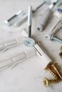 Set of various plastic dowels with metal screws of different sizes placed on white marble table in modern workshop