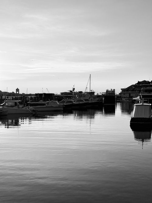 Free Serene morning view of Boston Harbor with boats and reflections. Stock Photo