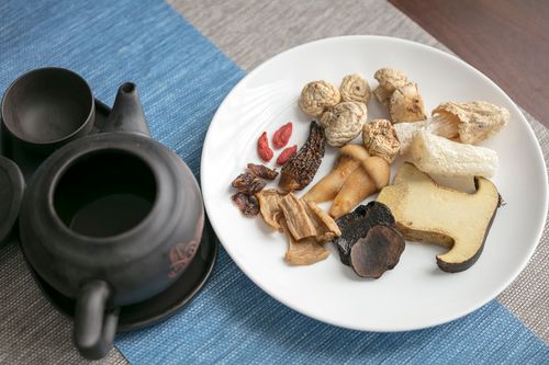 Free A plate of assorted dried Chinese herbs and mushrooms with a traditional teapot. Stock Photo