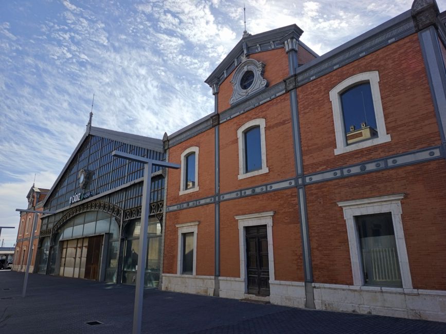 Exterior de la estación de tren de Cádiz que muestra su arquitectura clásica bajo un cielo azul.