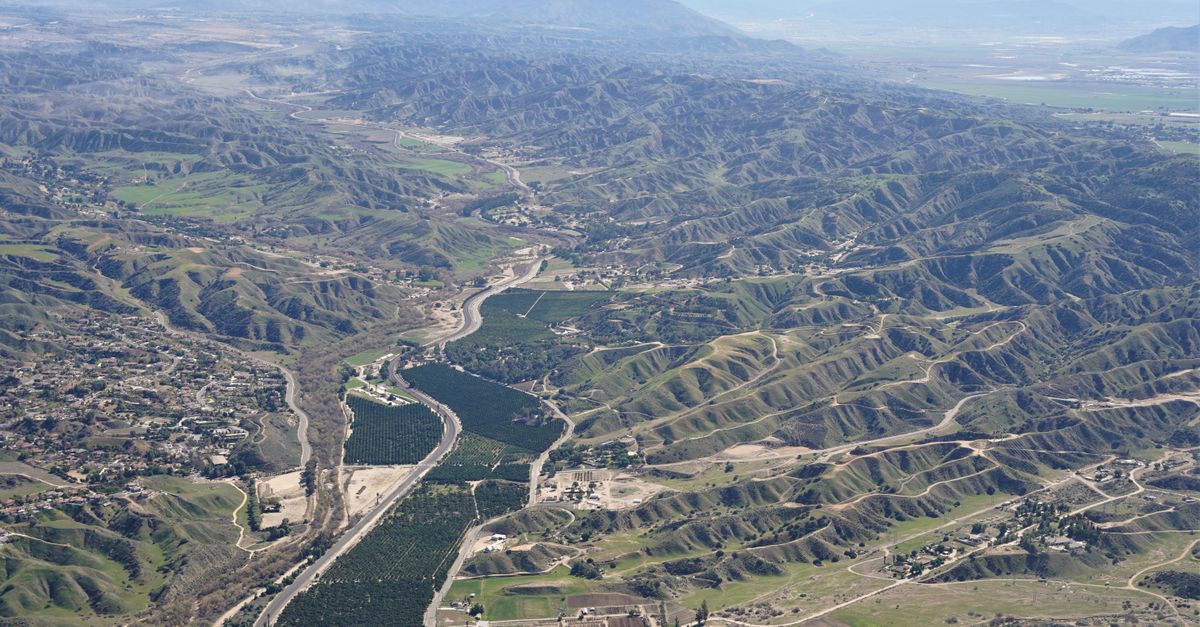 A stunning aerial view of lush hills with farms and roads weaving through the terrain.