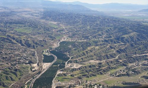Free A stunning aerial view of lush hills with farms and roads weaving through the terrain. Stock Photo