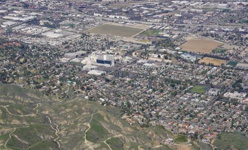 Free An expansive aerial view capturing a cityscape with urban sprawl and surrounding hills. Stock Photo