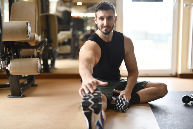 Athlet dehnt sich im Fitnessstudio