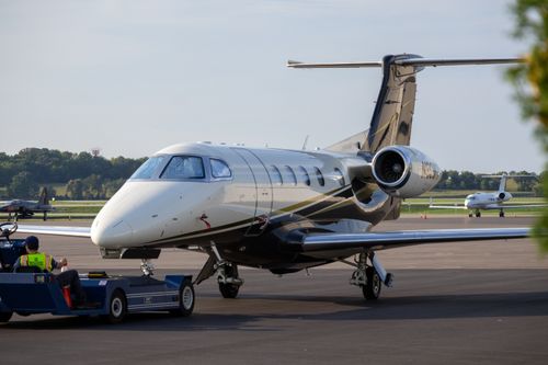 Free A private jet being serviced on an airport tarmac with clear skies. Stock Photo