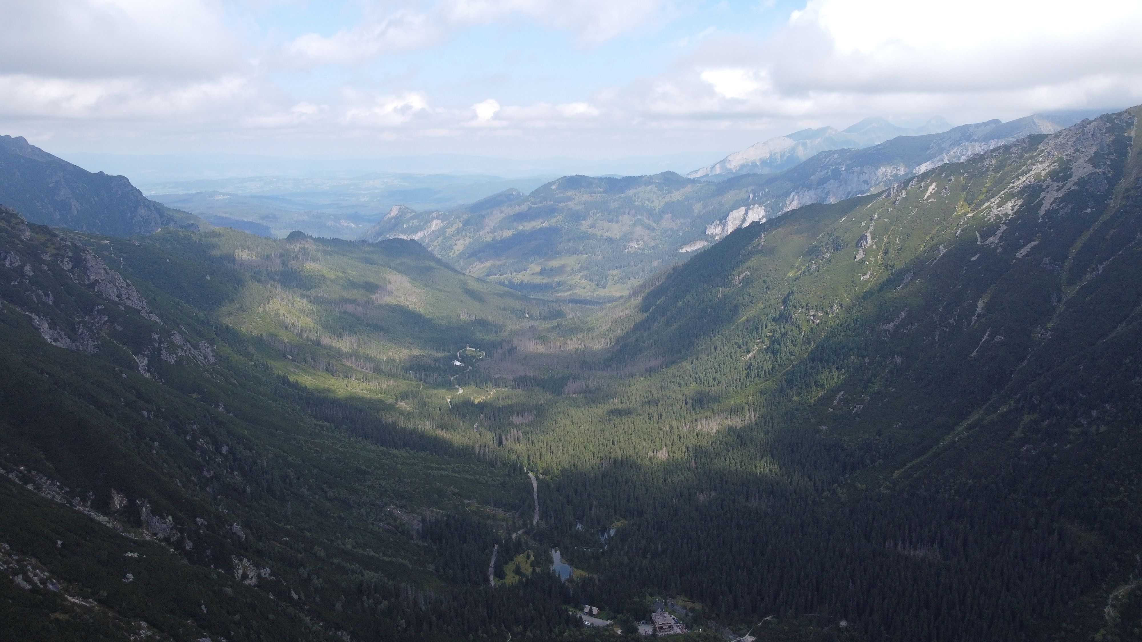 Scenic aerial view of the Tatra Mountains in Zakopane, Poland with lush greenery and rolling hills.