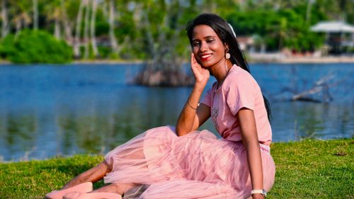 Free Beautiful outdoor portrait of a woman in a pink tulle dress by a tranquil lake. Stock Photo