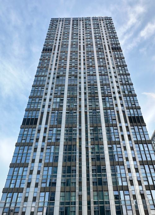 Free Vertical perspective of a modern skyscraper in Chongqing, China with a blue sky backdrop. Stock Photo