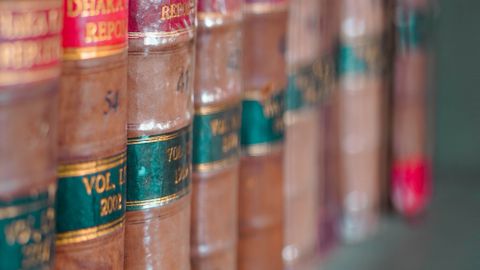 Close-up of leather-bound law books arranged neatly on a bookshelf, showcasing traditional literature.
