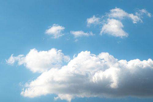 Free Captivating view of a serene blue sky adorned with fluffy white clouds under bright daylight. Stock Photo