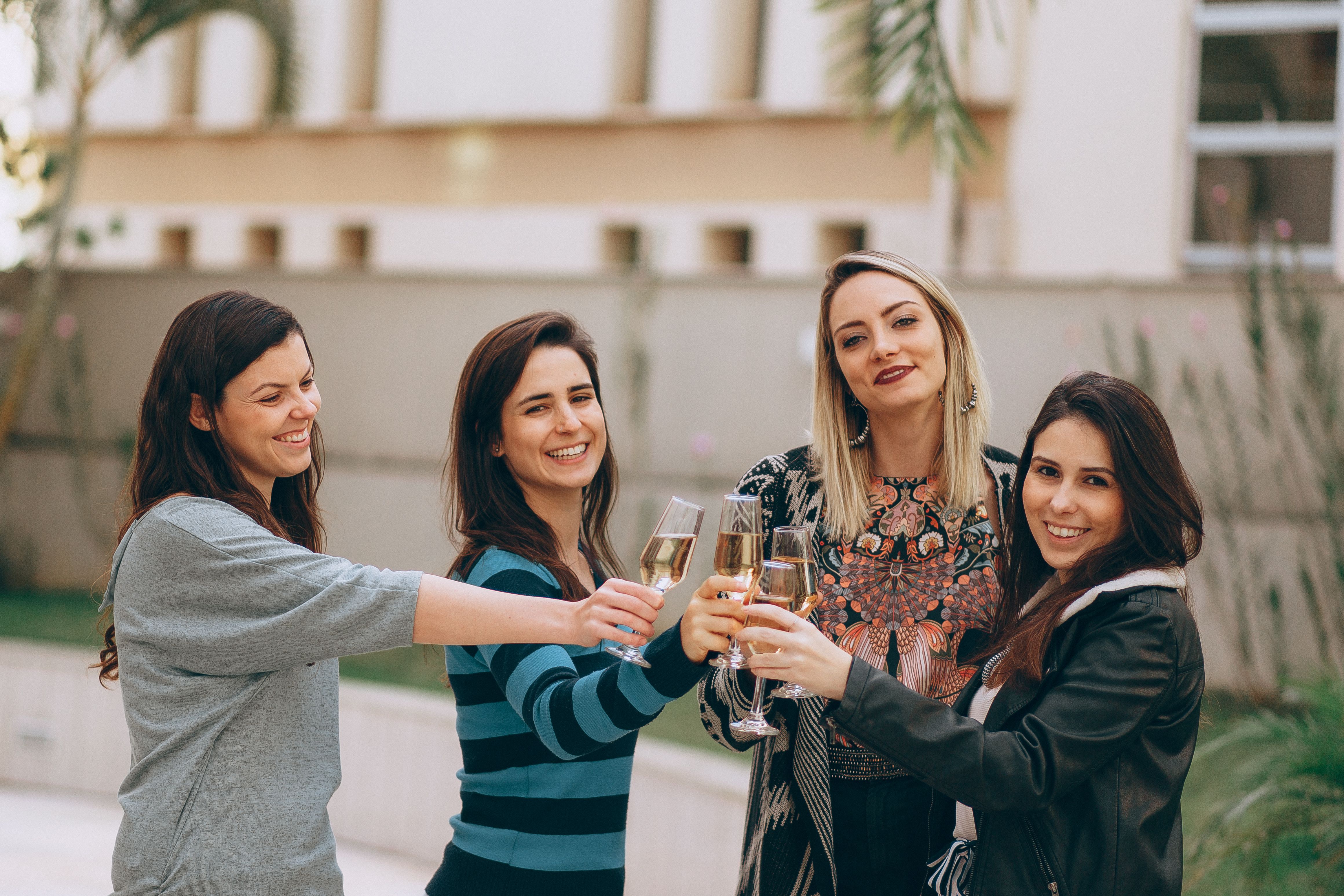 四名女子在户外微笑着举杯，象征着友谊和团结