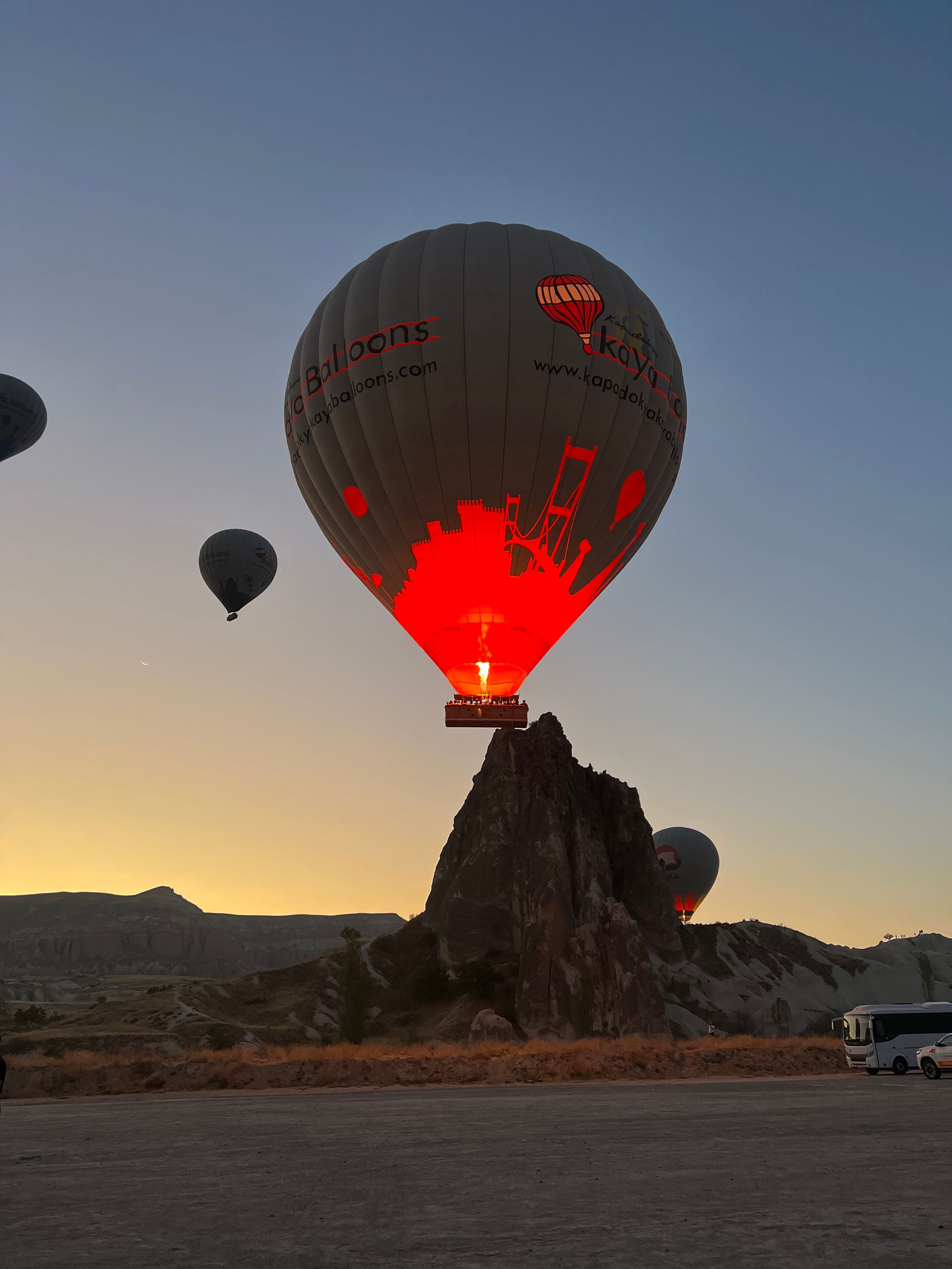 Hot air balloons illuminate the dawn over Cappadocia's unique landscape.