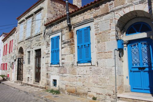 Free Charming Mediterranean stone houses with vibrant blue shutters and doors. Stock Photo