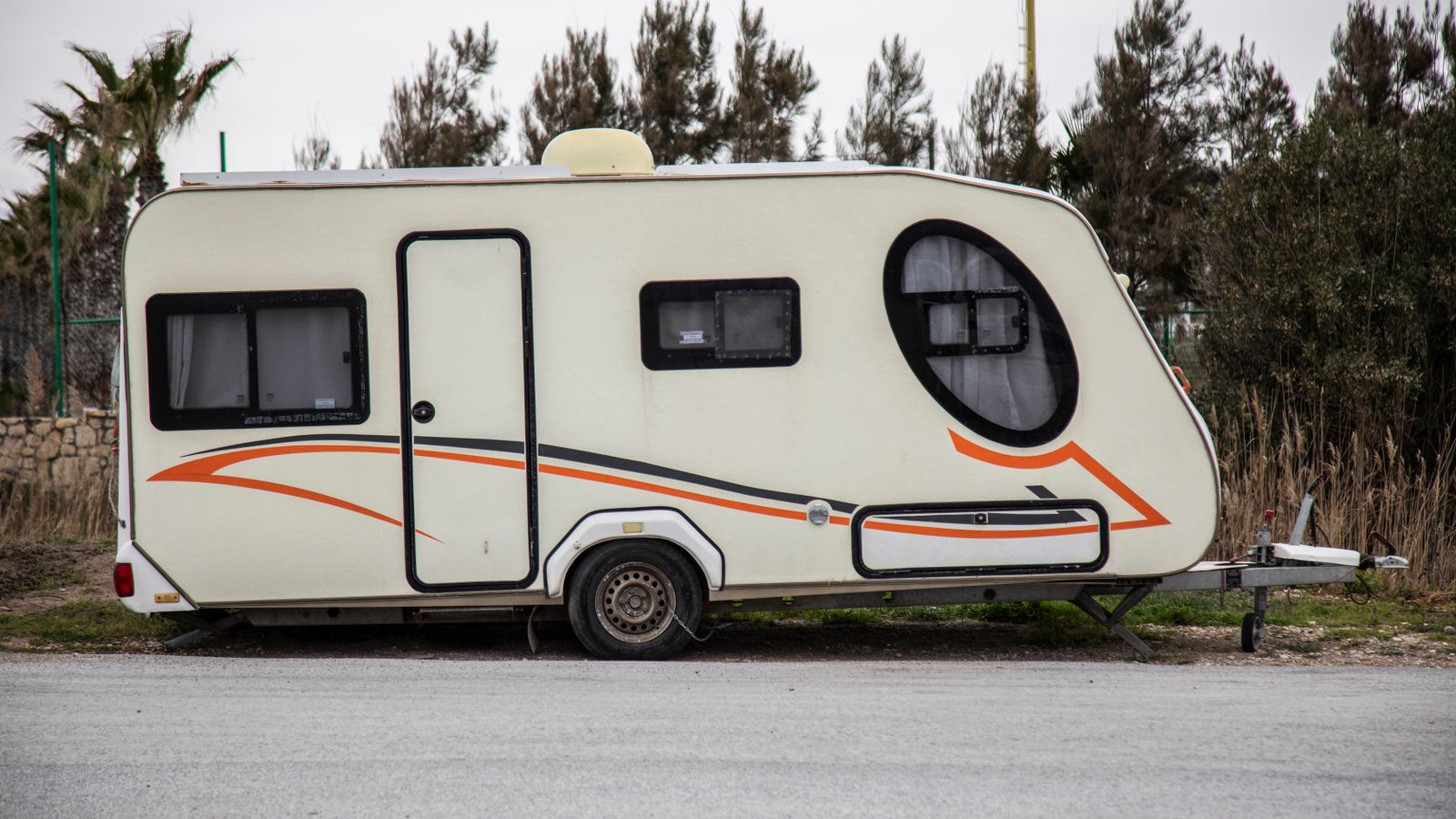 A modern white travel trailer parked outdoors, representative of a pop-up camper setup