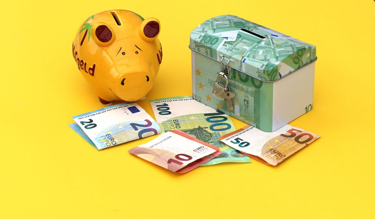 Yellow piggy bank and cash box on a bright background representing cost-effective referral rewards