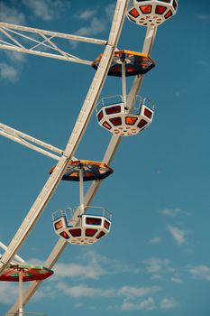 Ferris wheel in daylight with bright colors against a clear blue sky, offering a fun and vibrant theme.