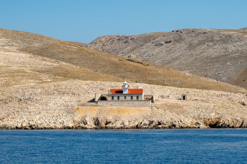 Free A solitary lighthouse on a rocky coastal landscape in Baška, Croatia. Stock Photo