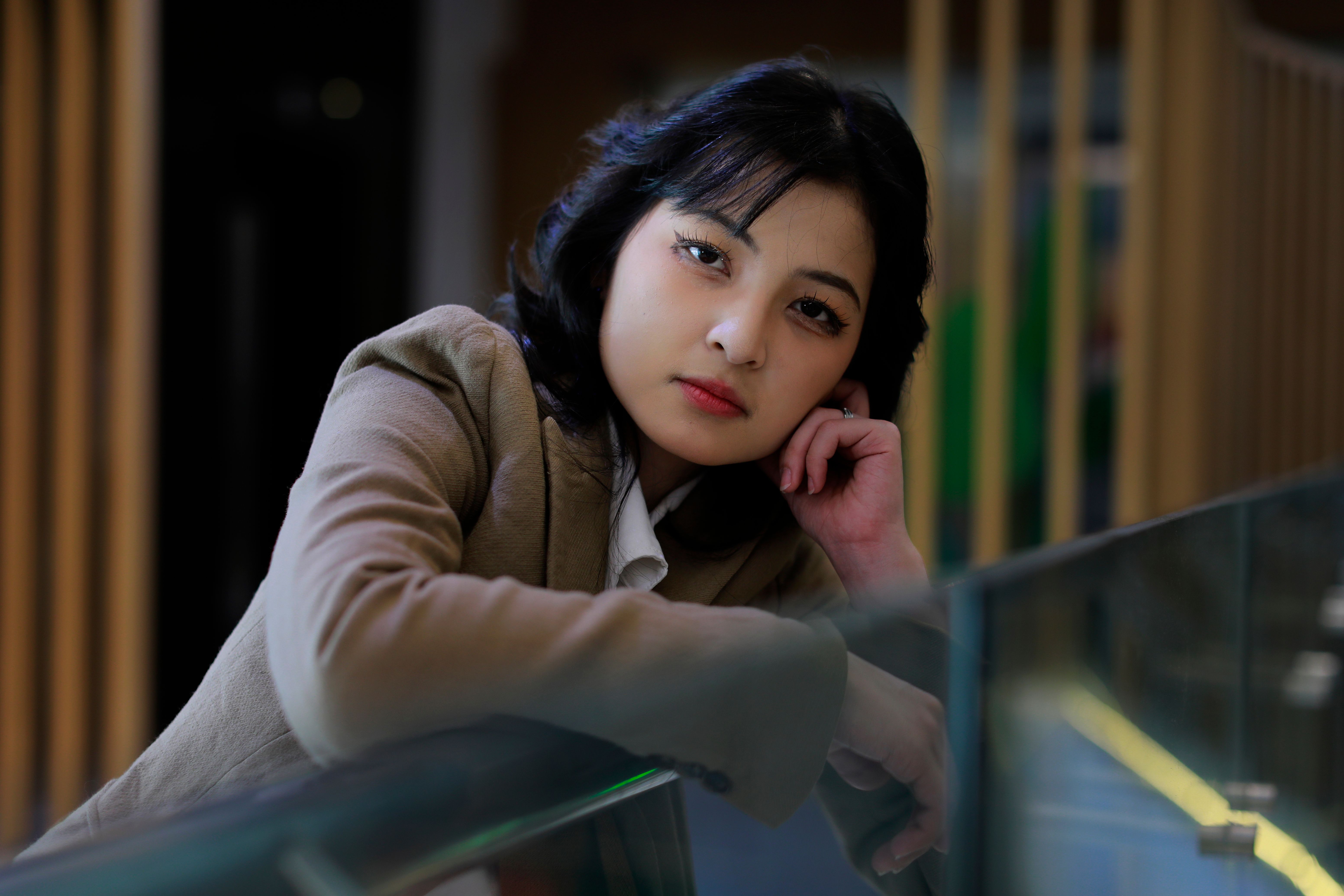 Graceful portrait of a woman relaxing indoors in Jakarta, exuding elegance and thoughtfulness.