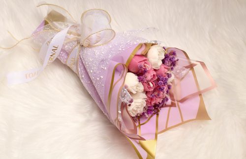 Free A beautifully arranged bouquet with pink and white flowers wrapped in decorative pink paper and ribbon. Stock Photo
