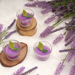 Lilac candles in small glasses among sprigs of lavender