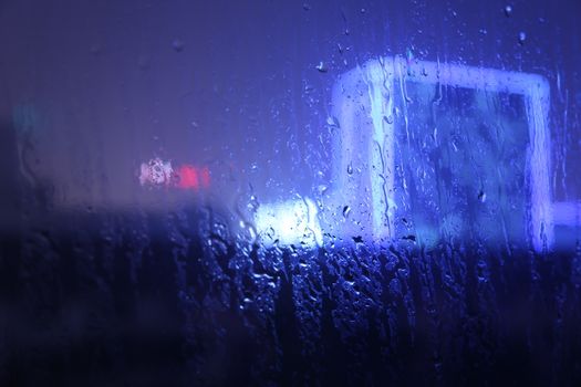 夜晚，雨水浸湿的窗户与模糊的城市灯光，共同营造出一种喜怒无常的城市氛围