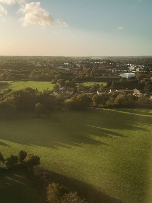 Free Aerial photograph capturing the serene Spanish countryside with lush fields during sunset. Stock Photo