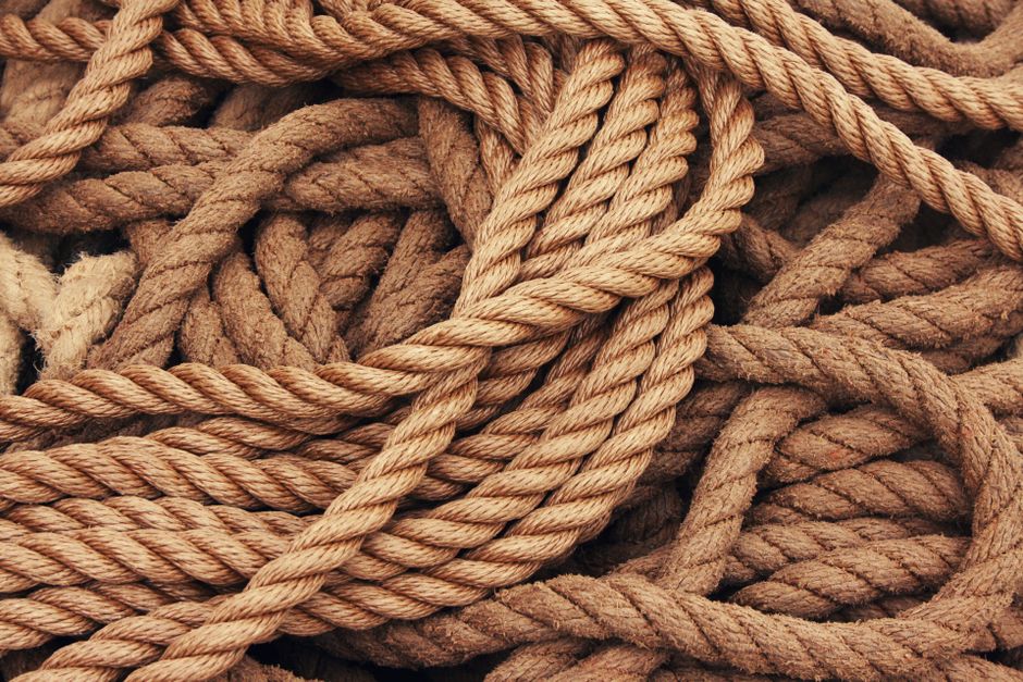 Detailed close-up view of intertwined brown ropes used as ship accessories.