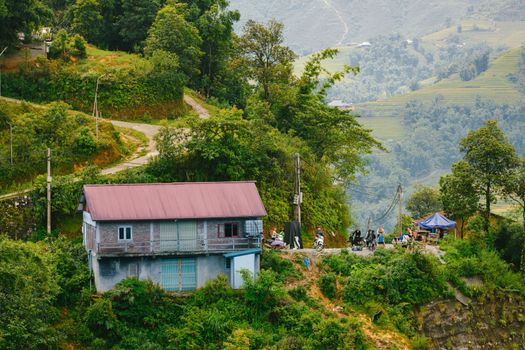 A picturesque rural house surrounded by lush greenery and distant mountain views, capturing serene countryside life.