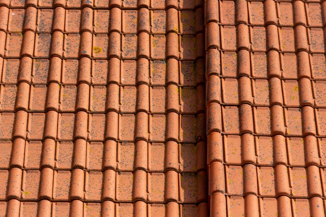 Rows of roof tiles on a home under a clear sky