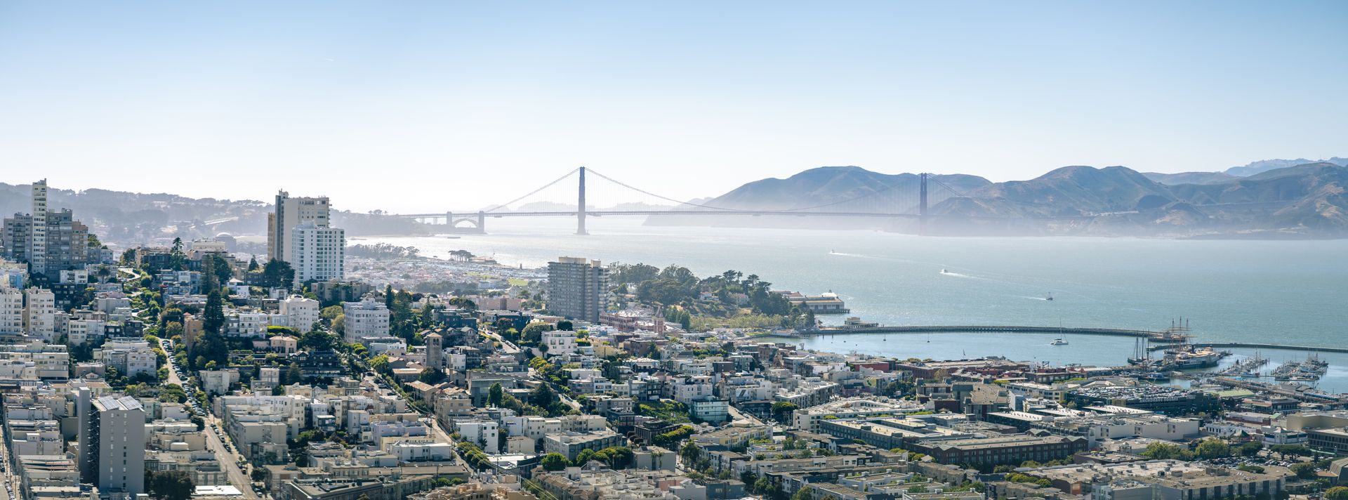Aerial view of San Francisco's Marina District with the bay, marina, and Golden Gate Bridge in the background on a clear day