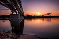 宁静的日落与平静水面上的桥梁，捕捉了生动的色彩和静谧的倒影