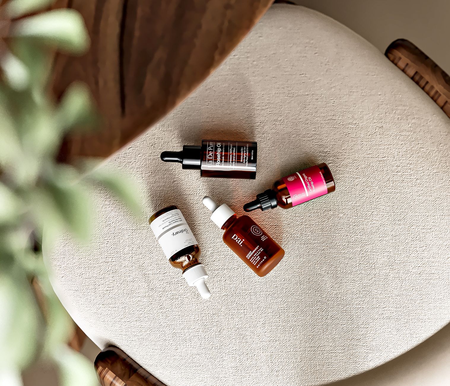 Top view of various natural skincare serums arranged on a chair, highlighting clean beauty and skin nourishment.