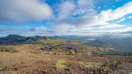 Free Expansive view of lush mountains and valleys under a bright blue sky. Stock Photo