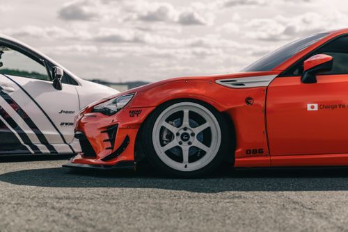 Free Dynamic shot of sleek red and white sports cars on a highway ready to race. Stock Photo