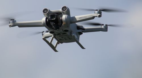 Free Close-up view of a drone in flight against a clear sky, emphasizing technology and innovation. Stock Photo