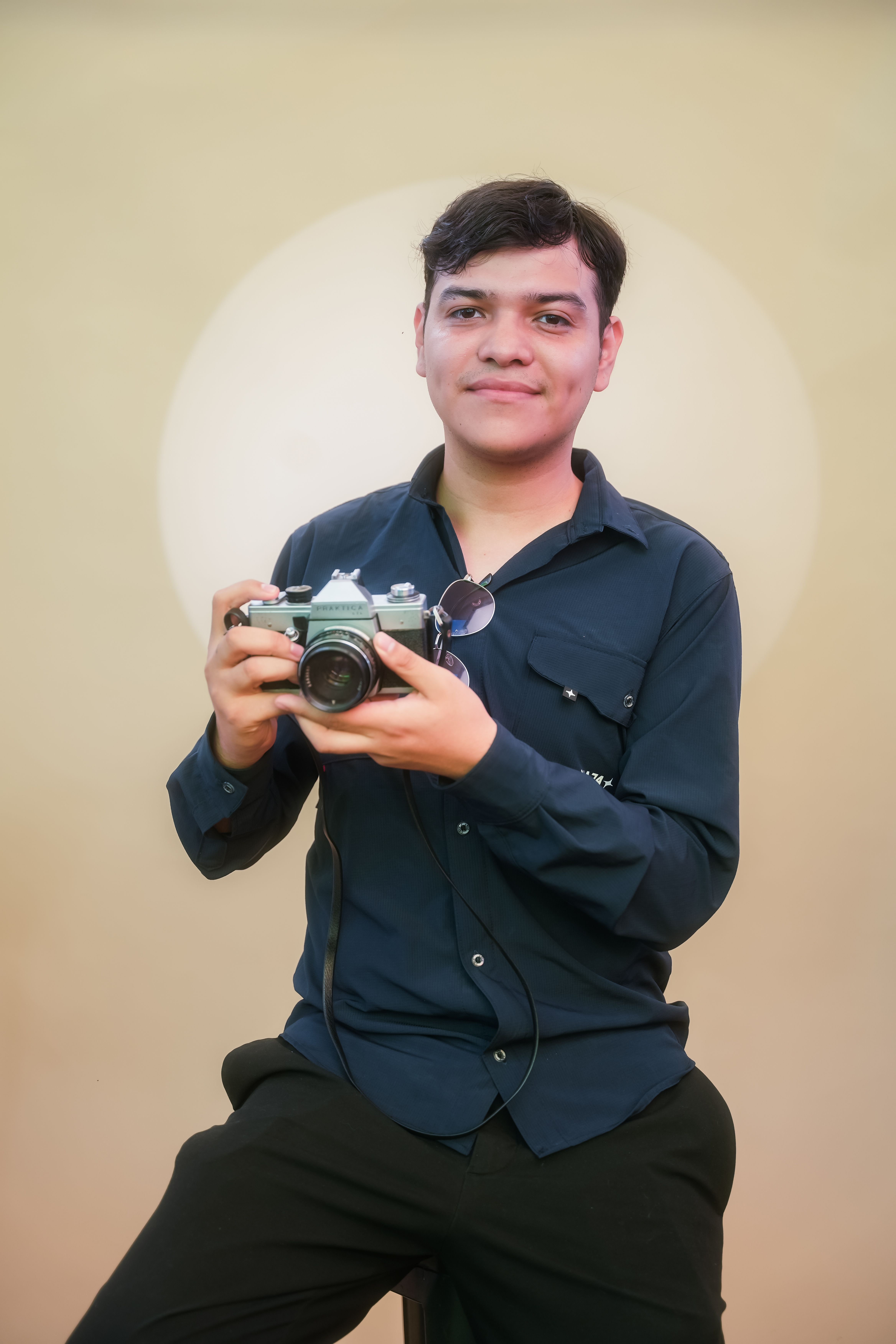 Young man holding vintage camera in studio, Irapuato, Mexico