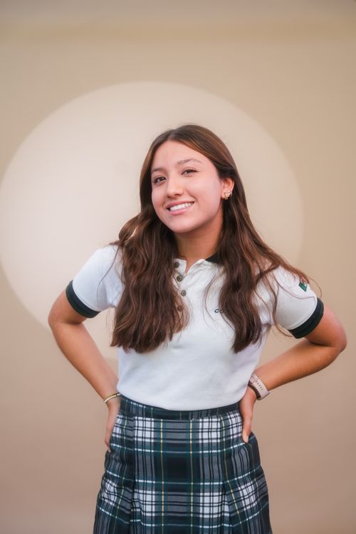Free A confident student smiles in a classic plaid school uniform against a neutral backdrop. Stock Photo