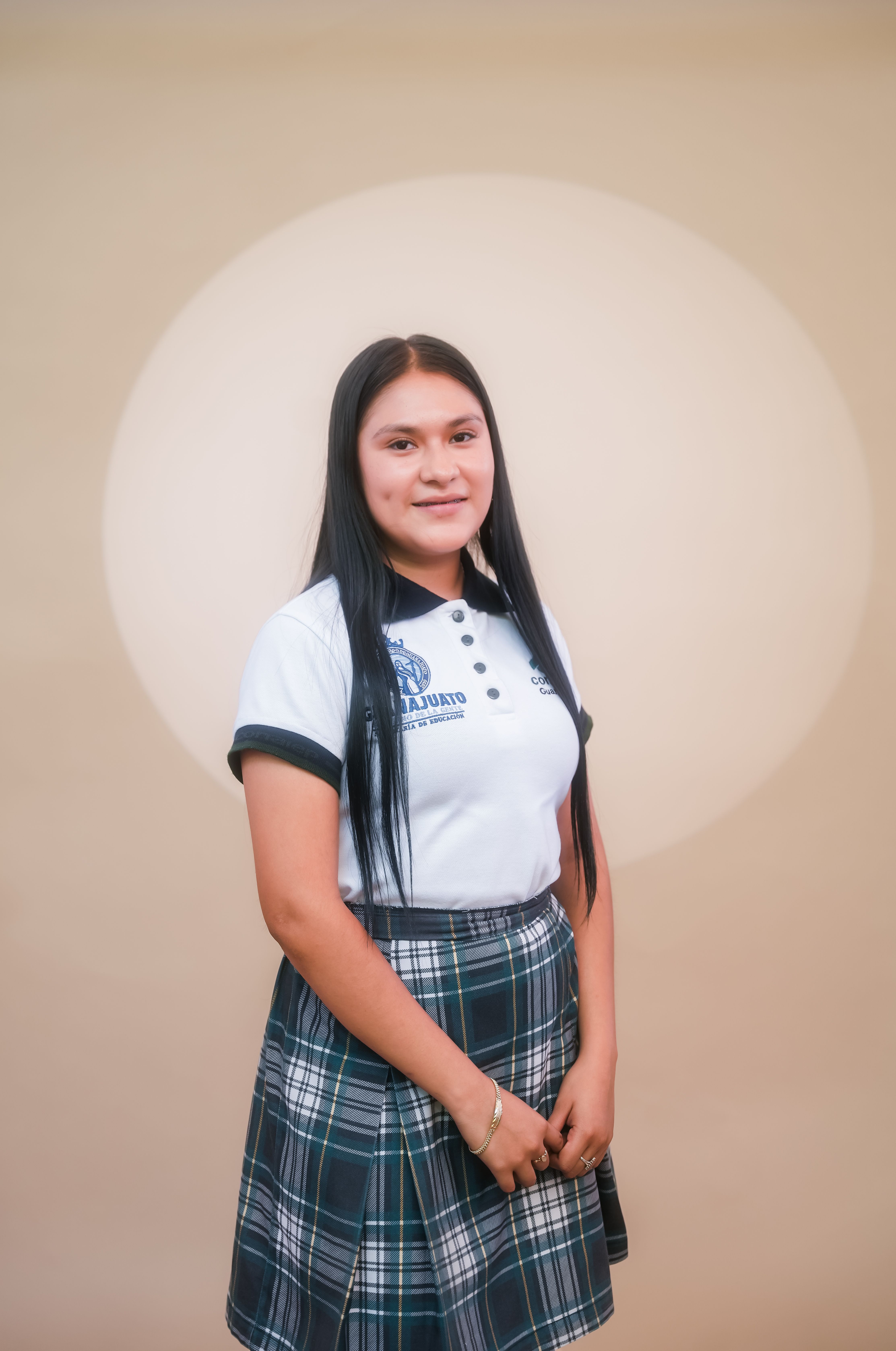 Confident teenage girl in a school uniform posing in the studio.