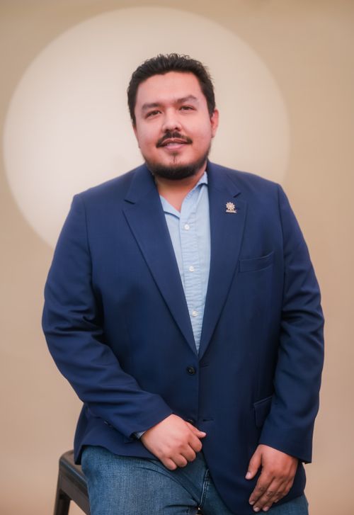 Free Portrait of a Hispanic man in a blue suit with a soft light background. Ideal for professional use. Stock Photo
