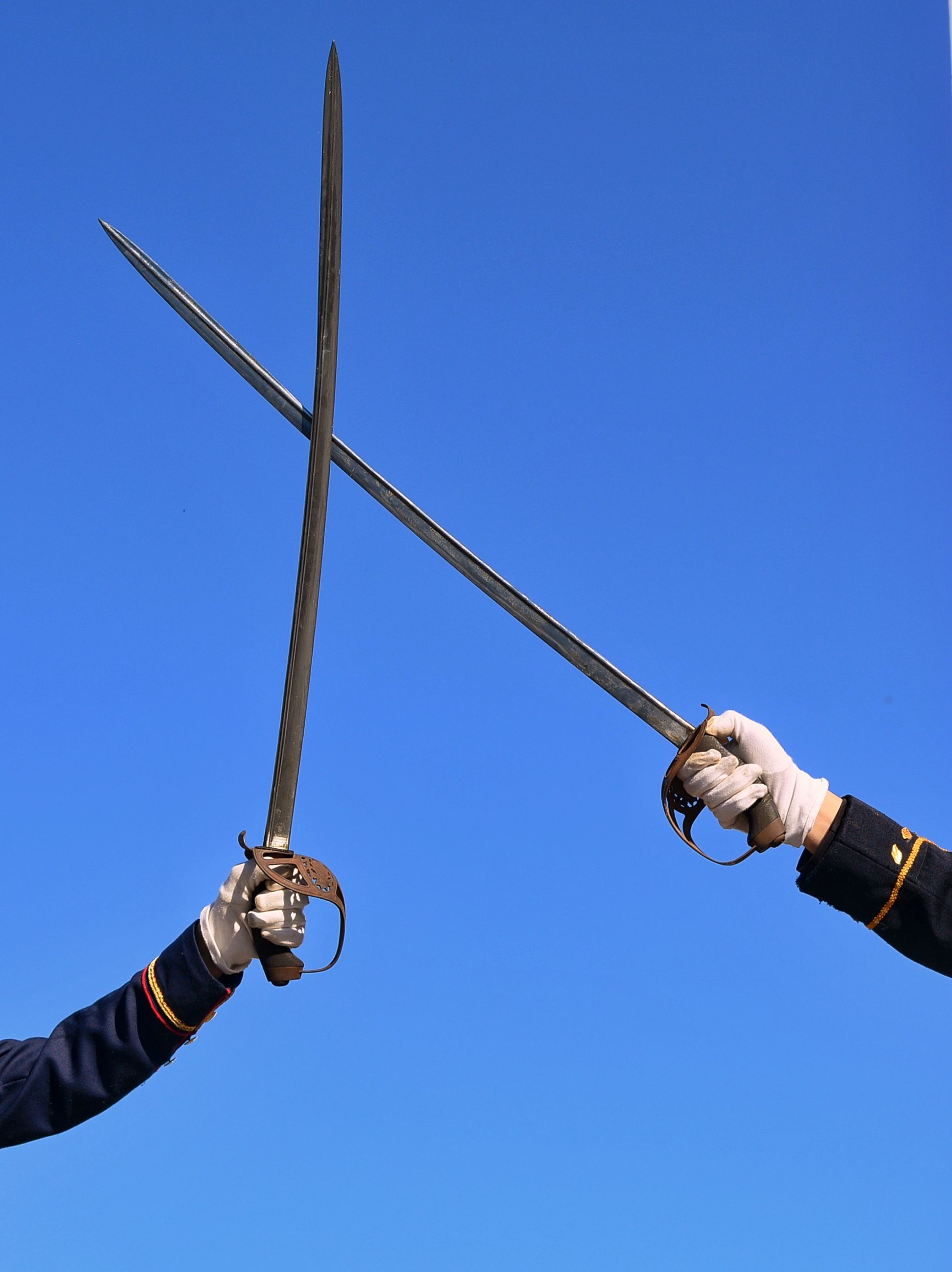 Two swords crossed in a clash against a clear blue sky, a real stock photo of a sword duel chosen as a nod to the blade fights in Phantom Blade Zero