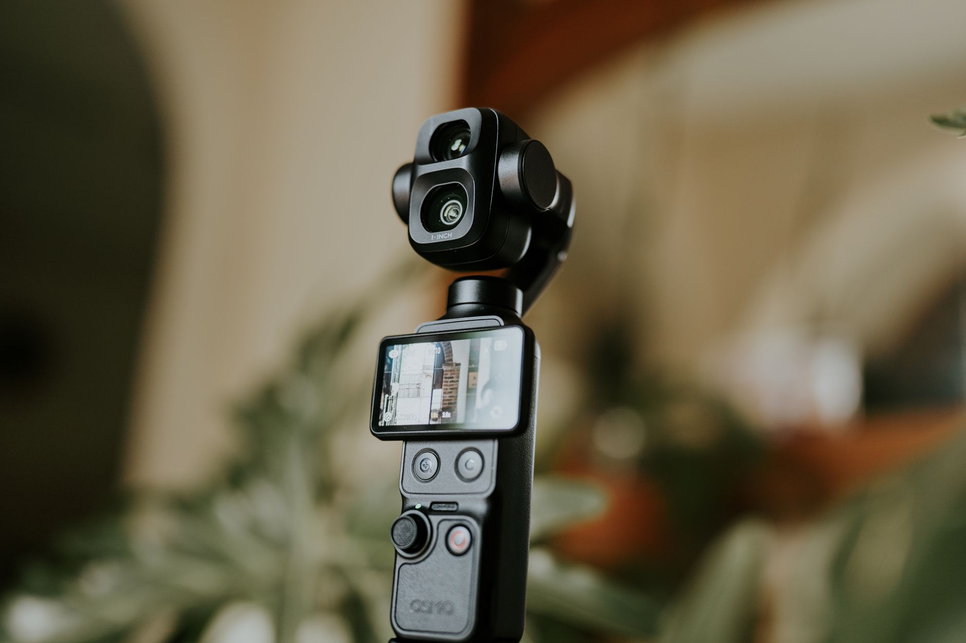 Close-up of a modern camera gimbal stabilizer with digital display, indoors.